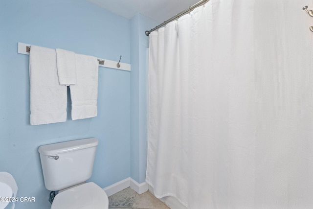 bathroom featuring tile flooring and toilet