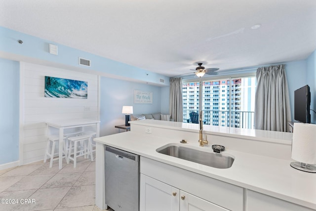 kitchen featuring light tile floors, ceiling fan, white cabinetry, dishwasher, and sink