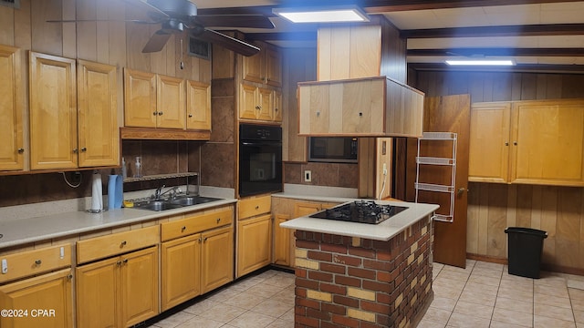 kitchen with ceiling fan, black appliances, light tile patterned flooring, beamed ceiling, and sink