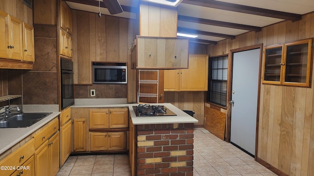 kitchen featuring light tile patterned flooring, black appliances, sink, lofted ceiling with beams, and wood walls