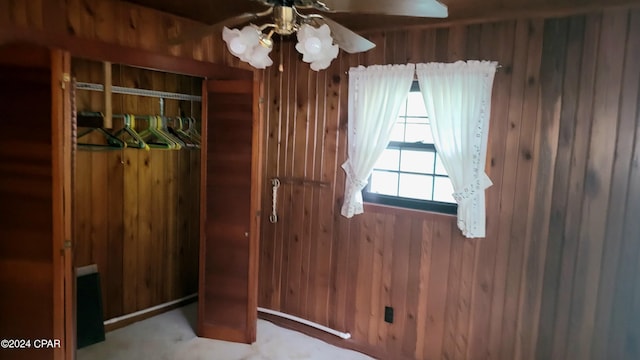 unfurnished bedroom with wood walls and ceiling fan