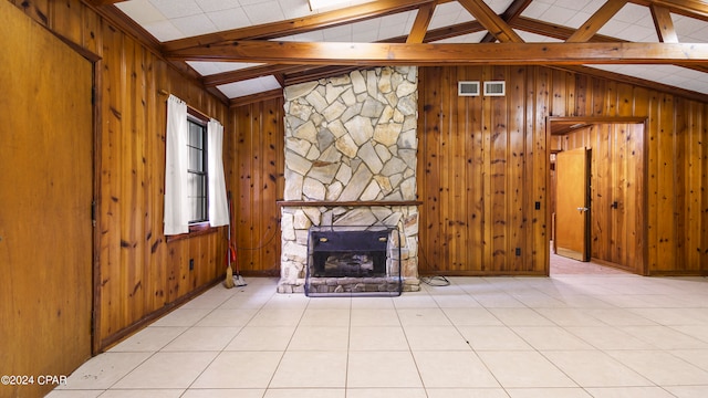 unfurnished living room featuring wood walls, a fireplace, lofted ceiling with beams, and light tile patterned floors