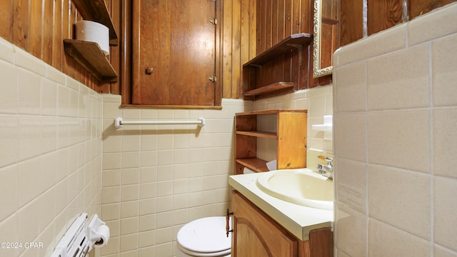 bathroom featuring tile walls, toilet, and vanity