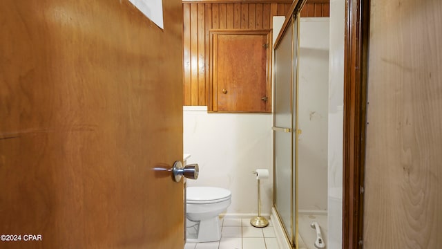 bathroom with toilet, tile patterned floors, and a shower with shower door