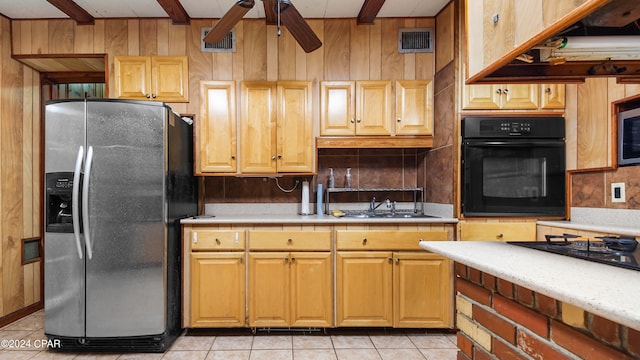 kitchen with light tile patterned floors, ceiling fan, sink, black appliances, and beamed ceiling