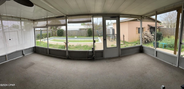 unfurnished sunroom featuring ceiling fan