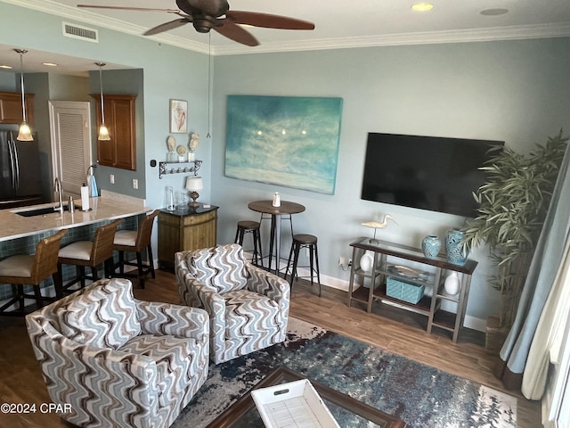 living room with dark wood-style flooring, a ceiling fan, visible vents, baseboards, and crown molding