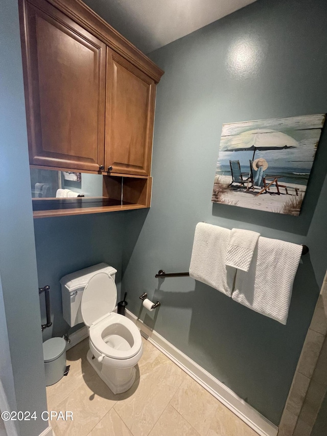 half bath with toilet and baseboards