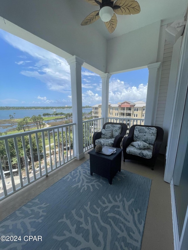 balcony with a ceiling fan and a water view