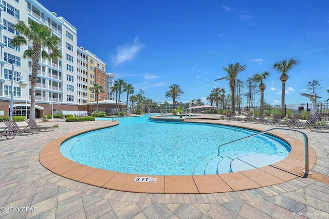 community pool with a patio area and fence