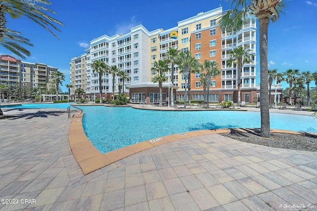 community pool with a patio and fence