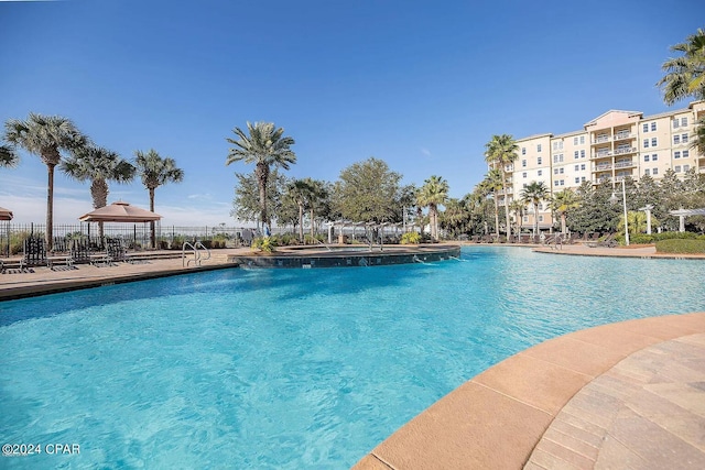 pool featuring fence and a gazebo