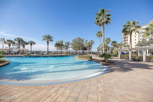 community pool with a patio area and a pergola