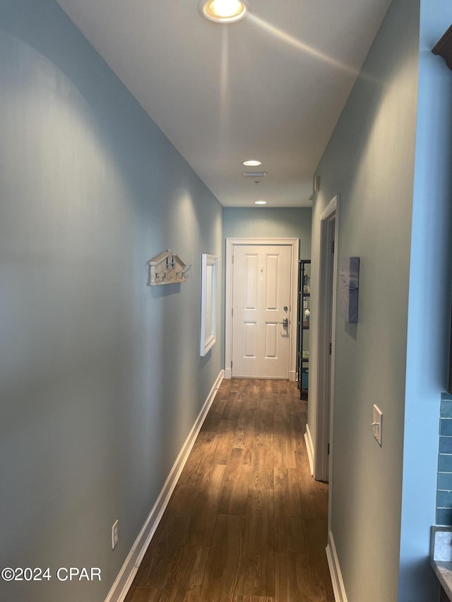 corridor with dark wood-style floors and baseboards