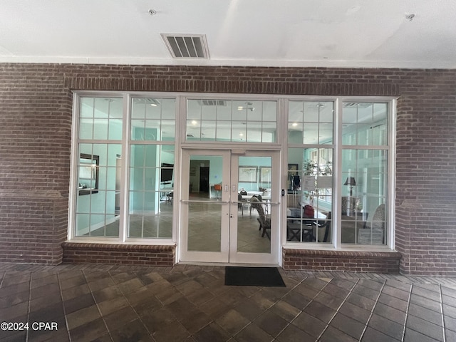 view of exterior entry with visible vents and french doors