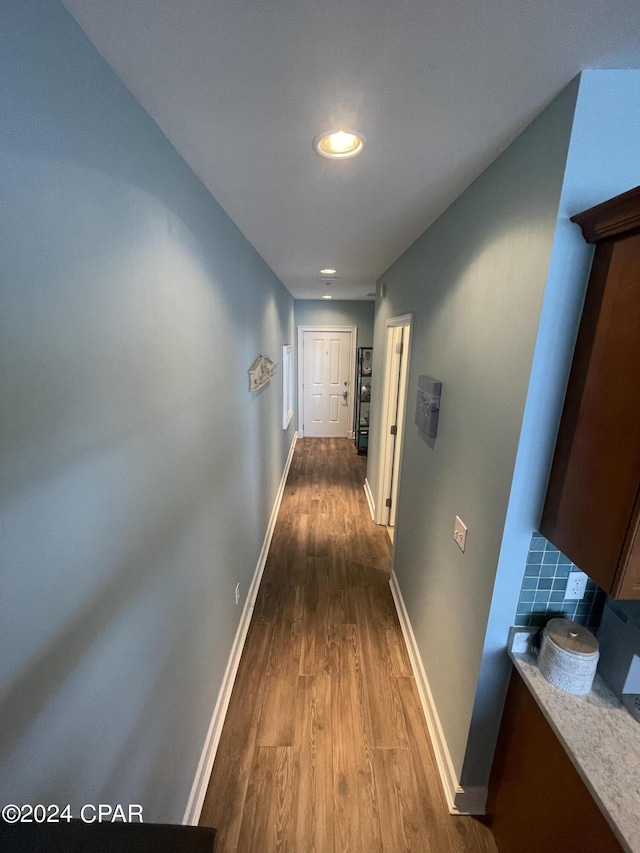 hall with baseboards and wood finished floors