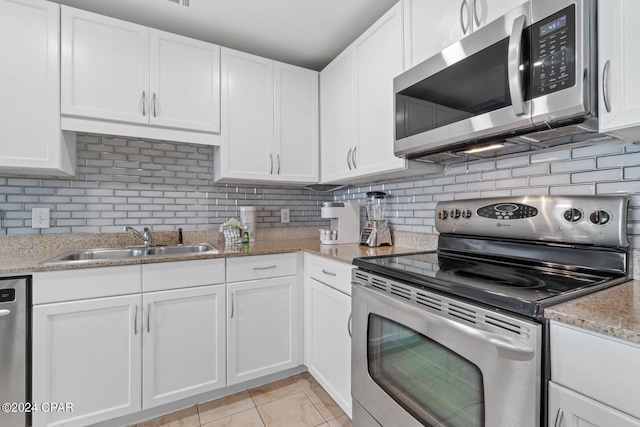 kitchen with tasteful backsplash, light tile floors, and appliances with stainless steel finishes