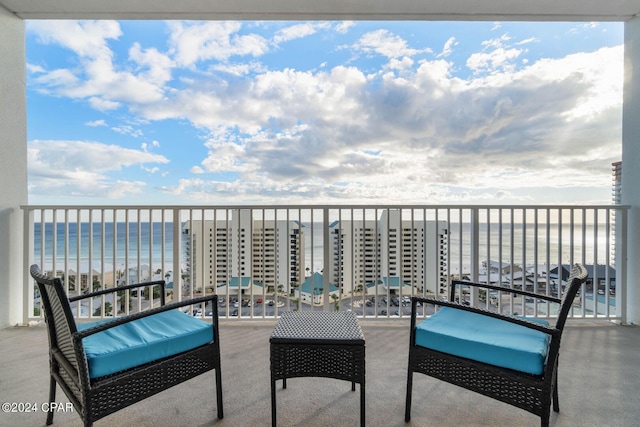 balcony featuring a view of the beach and a water view