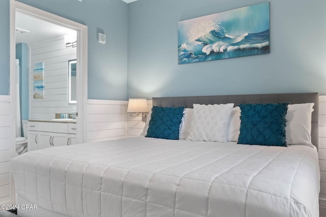 bedroom featuring ensuite bathroom and sink