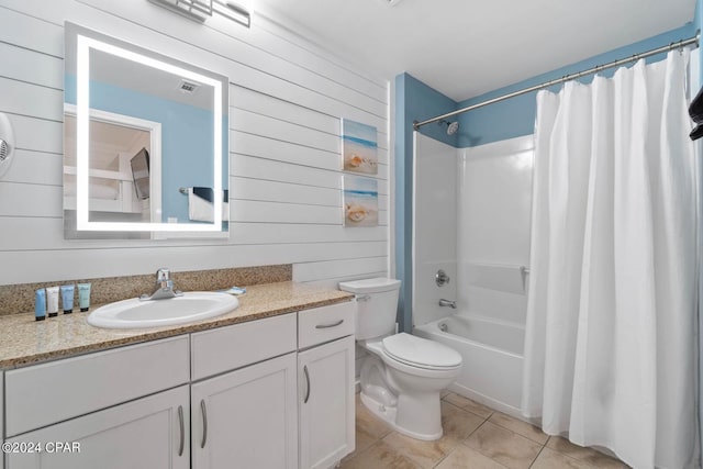 full bathroom featuring toilet, vanity, wooden walls, tile flooring, and shower / tub combo with curtain