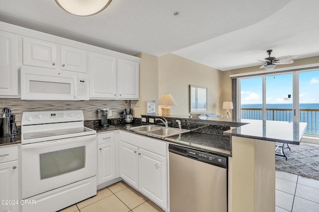 kitchen featuring a water view, white appliances, kitchen peninsula, and sink