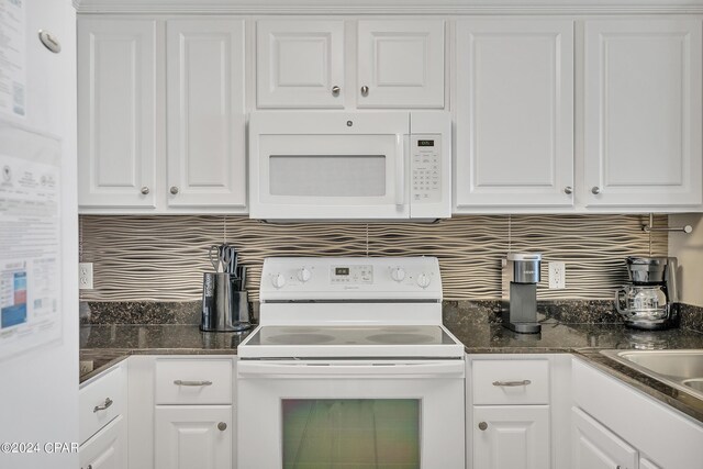 kitchen featuring light tile patterned flooring, a breakfast bar area, white cabinetry, tasteful backsplash, and white appliances