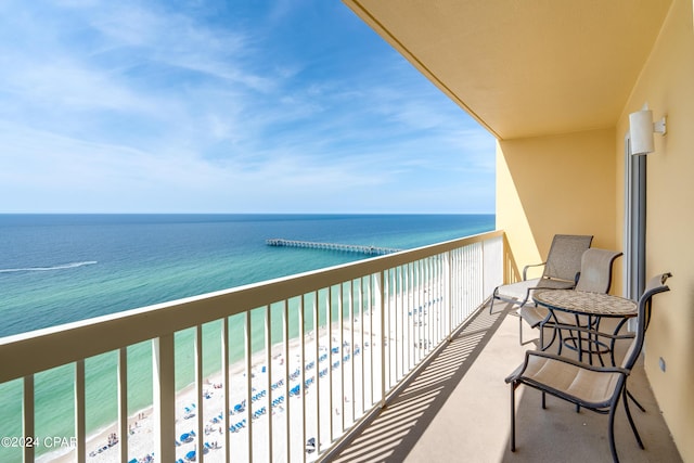 balcony featuring a water view and a beach view