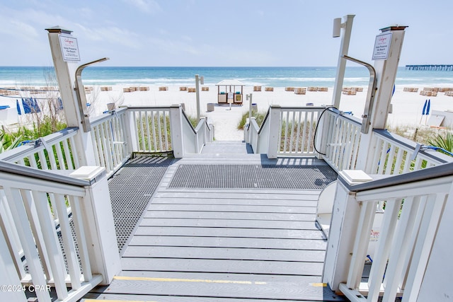 deck featuring a beach view and a water view