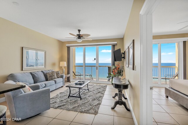 living room featuring a water view and light tile patterned floors