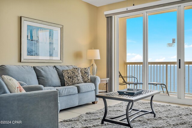 living room featuring a water view and light tile patterned floors