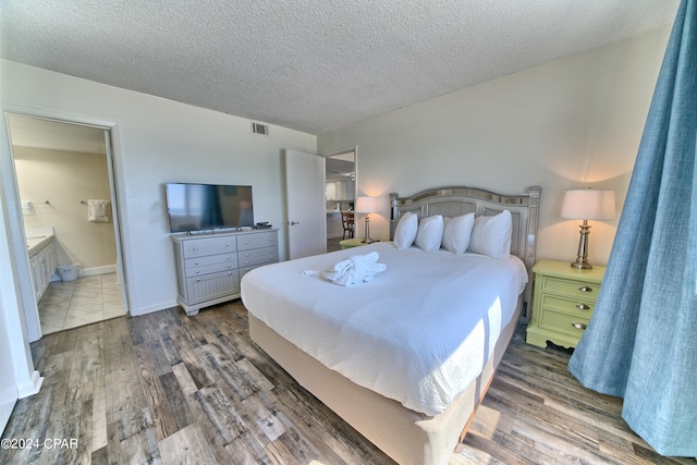 bedroom featuring a textured ceiling, connected bathroom, and dark hardwood / wood-style flooring