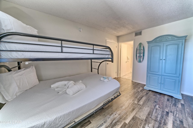 bedroom featuring a textured ceiling and hardwood / wood-style flooring