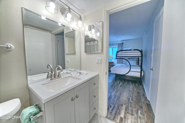 bathroom with vanity, hardwood / wood-style floors, and toilet