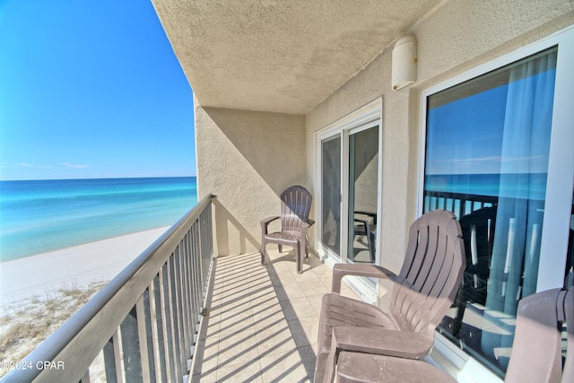 balcony featuring a water view and a view of the beach