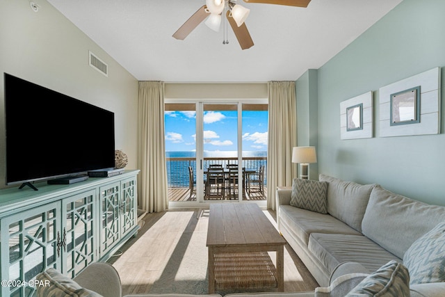 living room with ceiling fan, hardwood / wood-style floors, and a water view