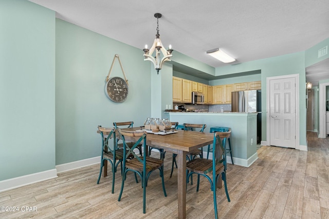 dining space with a chandelier and light wood-type flooring