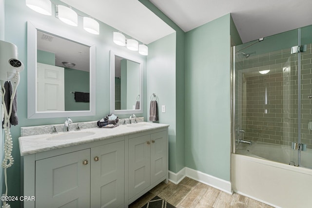 bathroom featuring dual bowl vanity, tiled shower / bath, and hardwood / wood-style floors