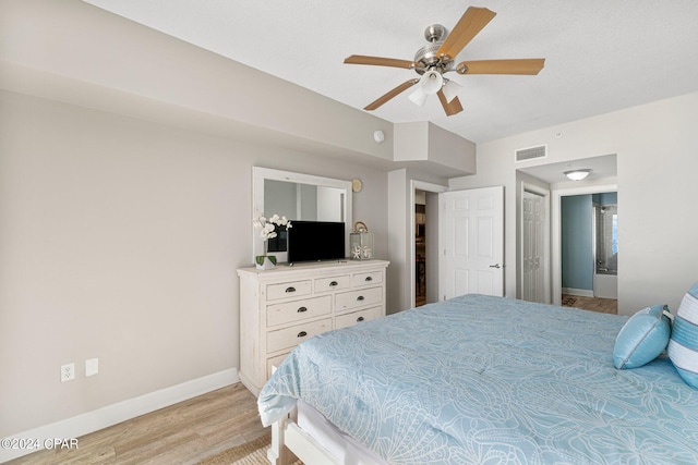 bedroom with ceiling fan, a closet, and light hardwood / wood-style floors