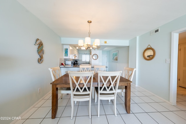 dining space with an inviting chandelier and light tile floors