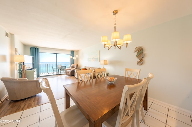 tiled dining area featuring a chandelier