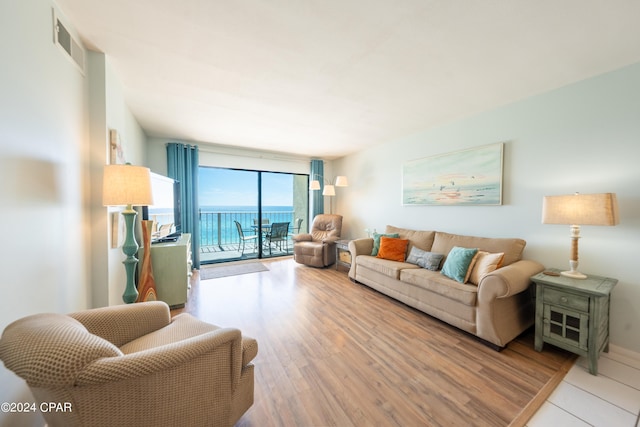 living room with hardwood / wood-style floors and a water view