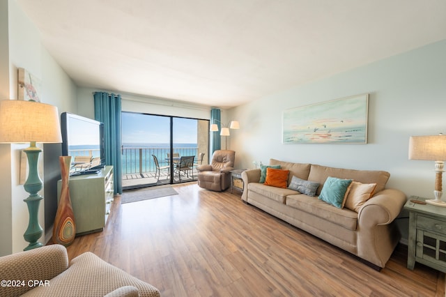 living room with wood-type flooring and a water view