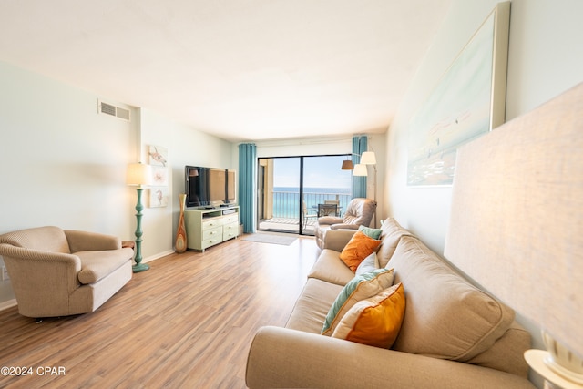 living room with hardwood / wood-style flooring and a water view