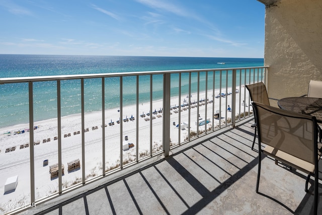 balcony featuring a beach view and a water view