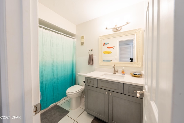 bathroom featuring tile flooring, vanity, and toilet