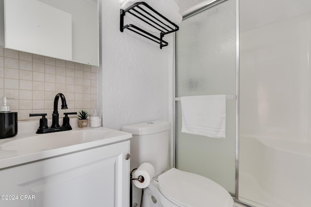 bathroom featuring vanity, backsplash, toilet, and walk in shower