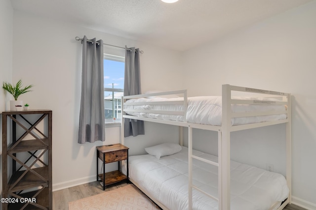 bedroom with wood-type flooring and a textured ceiling