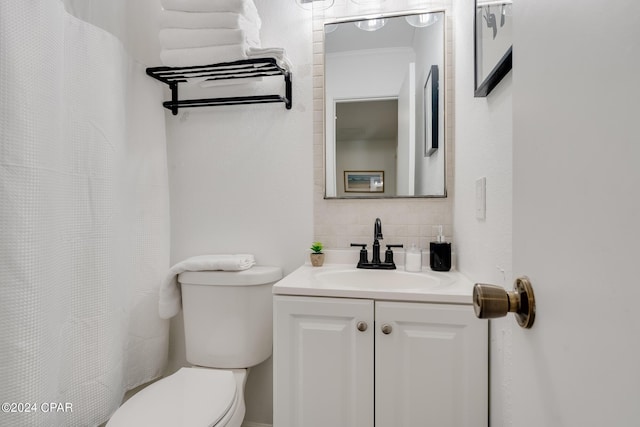 bathroom featuring vanity, backsplash, and toilet