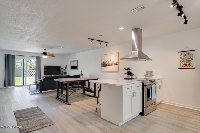 kitchen featuring light hardwood / wood-style floors, stainless steel electric range, island range hood, and white cabinetry