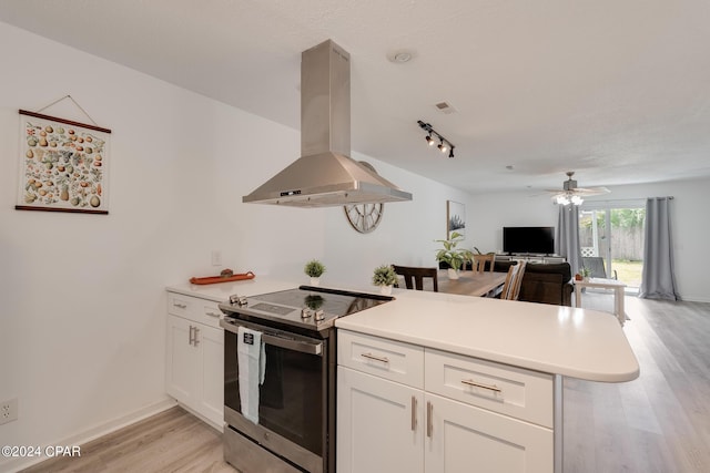 kitchen featuring electric range, island range hood, kitchen peninsula, and light hardwood / wood-style floors